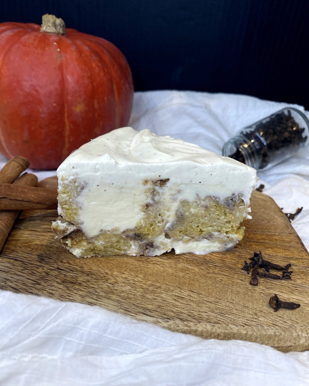 Slice of cinnamon roll cheesecake with cinnamon rolls baked into the base and crème fraîche topping